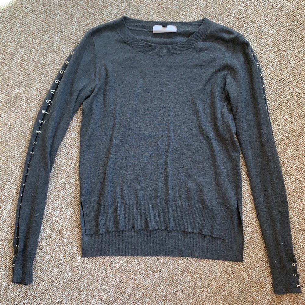 Gray sweater with metal ring details down the arms